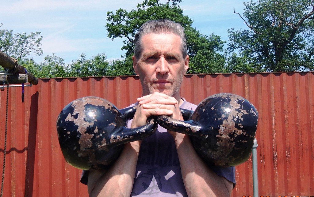 A Double Kettlebell Clean demonstrated by Personal Fitness Trainer at Outdoor Gym